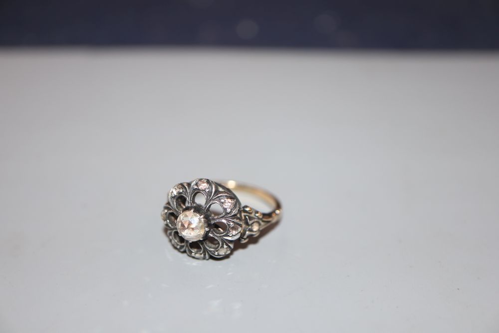 A 19th century yellow metal and diamond cluster set pierced openwork ring, size L, gross 5.6 grams.